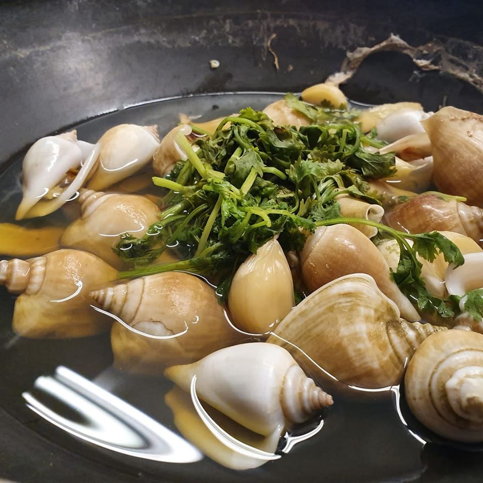 A plate of Bintan's iconic Gonggong sea snail served with traditional spicy dipping sauce.