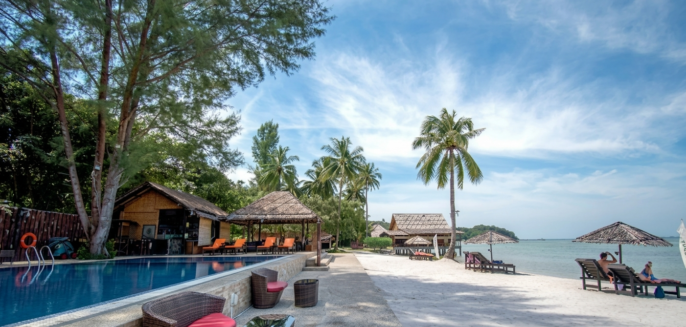 A wide-angle shot of a luxury resort in Bintan during the dry season (June), showing white sand and clear blue skies.